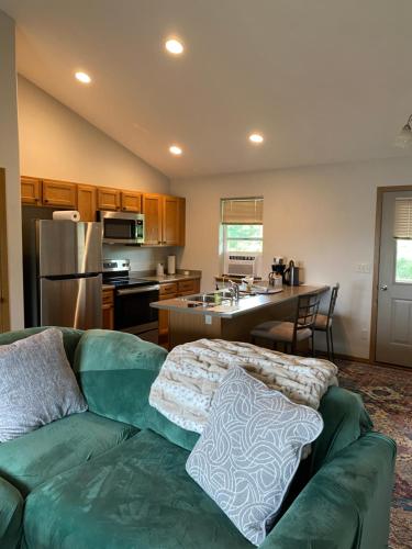 a living room with a green couch and a kitchen at Close to the Bozeman airport in Belgrade