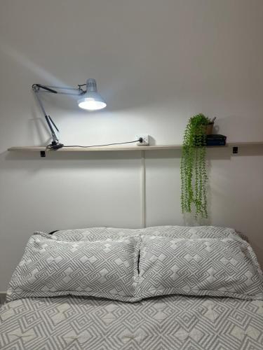 ein Schlafzimmer mit einem Bett mit einer Lampe und einer Anlage in der Unterkunft Hermoso Departamento en el corazón del centro santiagueño a 100 metros de la plaza principal, con estacionamiento privado in Santiago del Estero