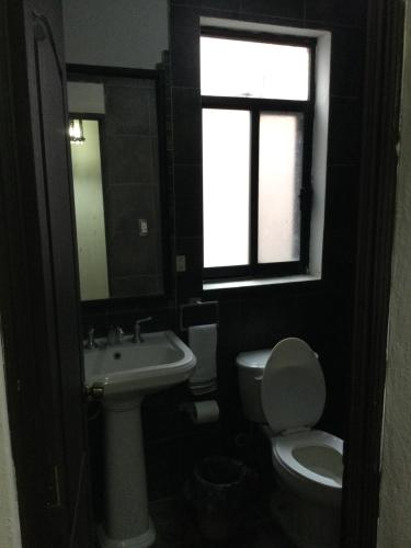 a bathroom with a sink and a toilet and a window at Trotamundo Oaxaca Hostel in Oaxaca City