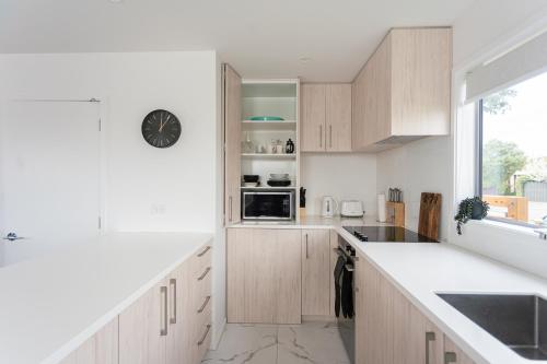 a kitchen with wooden cabinets and a counter top at Cosy 2 Bed 3 Bath Home Close to CBD And Hagley Park in Addington