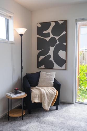 a living room with a couch and a table at Cosy 2 Bed 3 Bath Home Close to CBD And Hagley Park in Addington