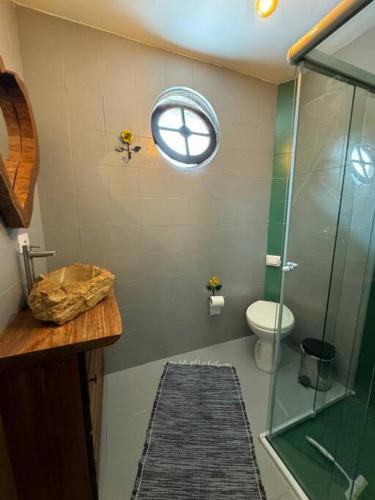 a bathroom with a glass shower and a toilet at Refúgio Natural com Praia Paradisíaca a 300m in Matinhos