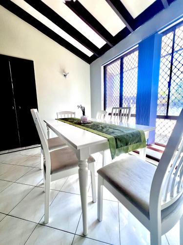 a dining room with a white table and chairs at 28 OFF Affordable Beautiful Queen Bedroom Near City Swan River Fremantle University in Perth