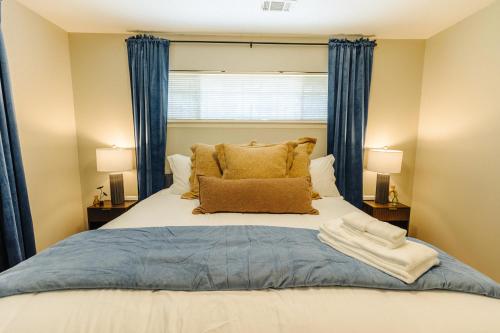 a bedroom with a large bed with blue curtains at Centrally Located 2 King Bed Midtown Memphis 2362 in Memphis