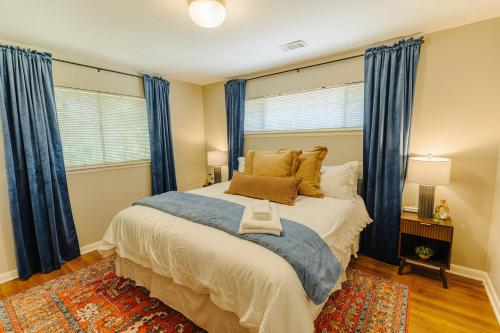 a bedroom with a large bed with blue curtains at Centrally Located 2 King Bed Midtown Memphis 2362 in Memphis