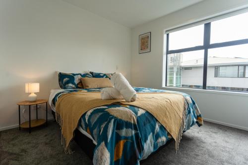 a bedroom with a bed and a large window at Modern 2 Bedroom Townhouse in CBD With Parking! Sleeps 5 in Christchurch