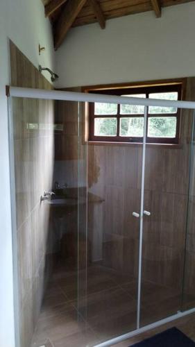 a shower with a glass door in a bathroom at Mini Casa in Baependi