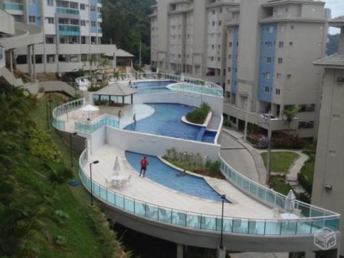 a person is standing on a walkway around a swimming pool at Mangaratiba Suite in Mangaratiba