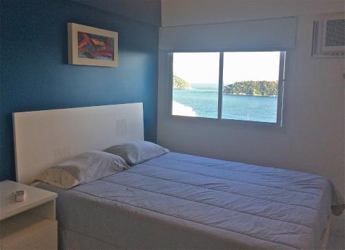 a bedroom with a large bed with a window at Mangaratiba Suite in Mangaratiba