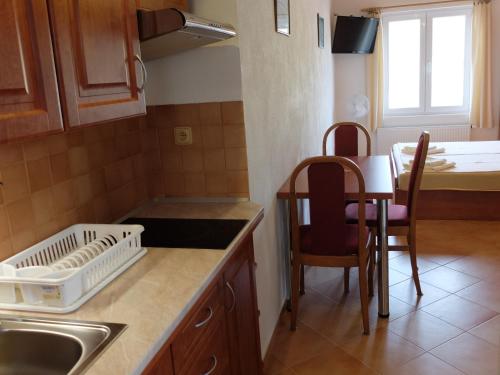 a kitchen with a sink and a table with chairs at Apartments Sunce in Brna