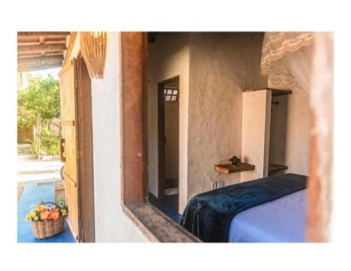 a bedroom with a bed and a door with a basket of fruit at Suíte Istambul Villas de São Jorge in Trancoso