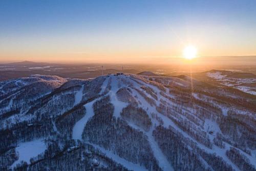an image of the sun setting on top of a mountain at Splendid Mountain View Condo with Pool & BBQ- Ski, MTB, Cycling, Golf, Telework! in Bromont