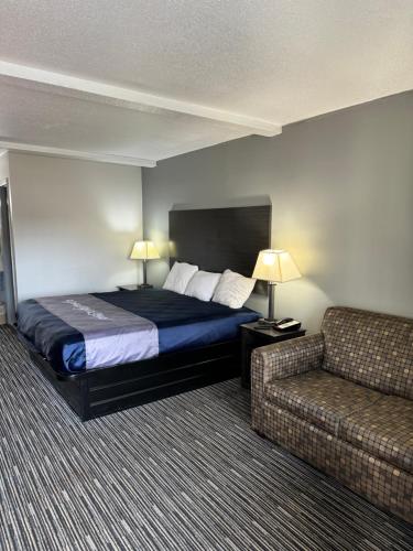 a hotel room with a bed and a couch at Scottish Inns - Locust Grove in Locust Grove