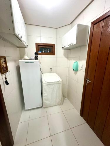 a small kitchen with a refrigerator and a trash can at Casa aconchegante em Lençóis in Lençóis