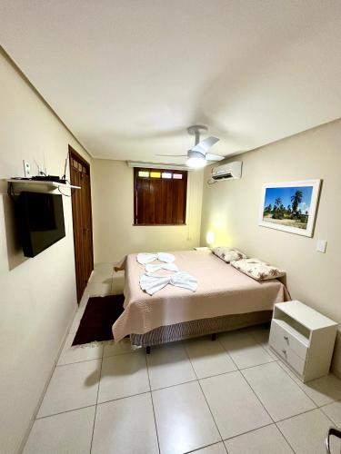 a bedroom with a bed and a television in it at Casa aconchegante em Lençóis in Lençóis