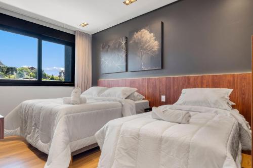 a bedroom with two beds and a window at Requinte a passos da Rua Torta by Achei Gramado in Gramado