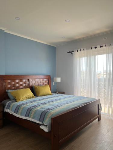 a bedroom with a large bed with yellow pillows at Departamento de lujo in Tarija