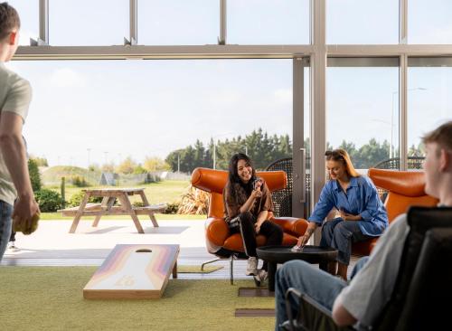 a group of people sitting in chairs in a room at LyLo Christchurch Airport in Christchurch