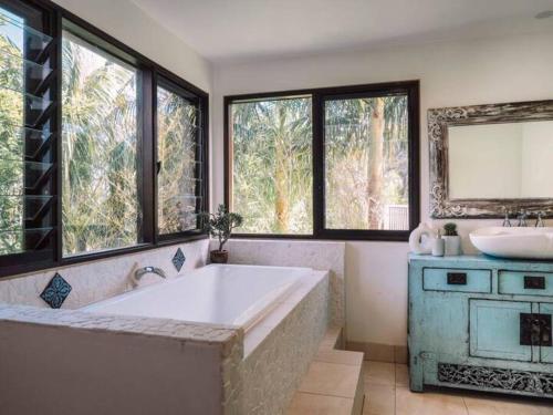 a large bathroom with a tub and a sink at Luxe Thirroul Home, Pool Spa Home Theatre in Thirroul