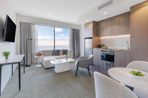 a room with a kitchen and a living room at Punthill Tuggeranong in Canberra