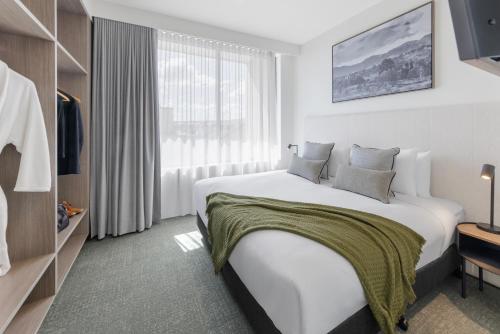 a hotel room with a large bed and a window at Punthill Tuggeranong in Canberra