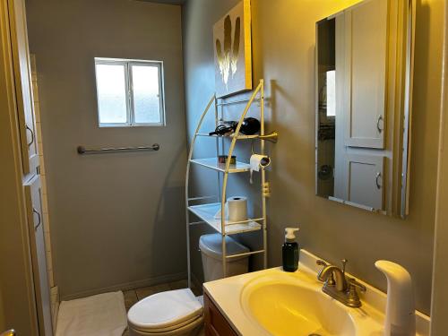 a bathroom with a sink and a toilet and a mirror at 洛杉矶东部花园式独立屋暂停 in El Monte