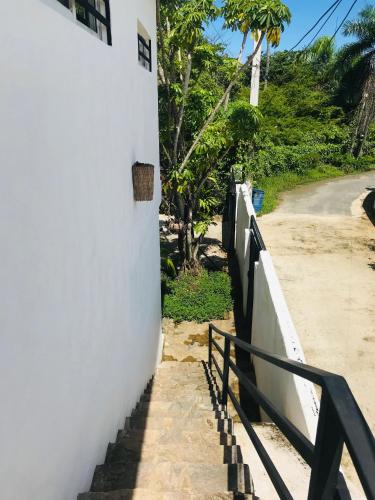 a stairway leading up to a white wall with a fence at NEW MORINGA in Las Terrenas
