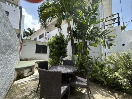 a patio with a table and chairs and a palm tree at NEW MORINGA in Las Terrenas