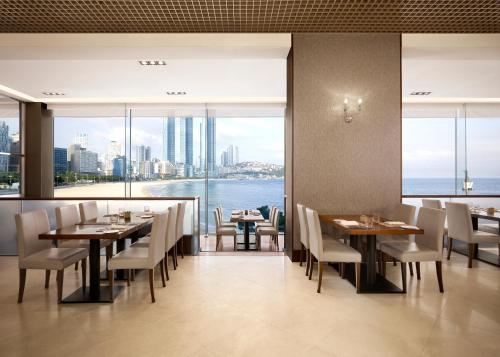 a restaurant with tables and chairs and a view of the water at The Westin Josun Busan in Busan