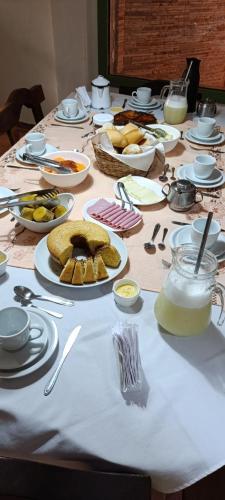 ein langer Tisch mit Tellern voller Essen darauf in der Unterkunft Pousada Terra Mar in Fundão