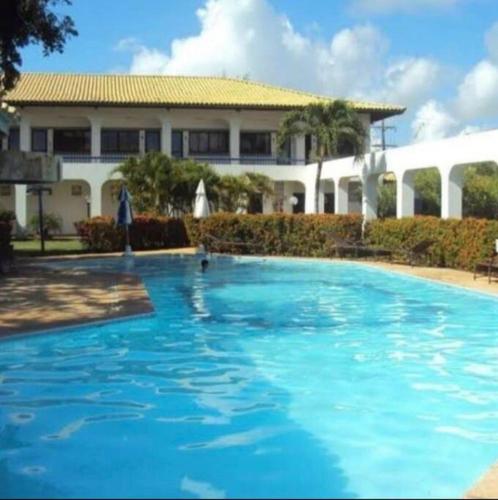 una grande piscina blu di fronte a un edificio di Guarajuba Summer Flat - 110 - Apartamento Inteiro a Camassari