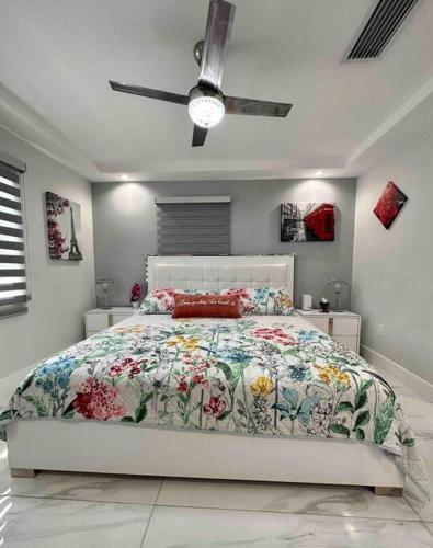 a bedroom with a large bed with a floral bedspread at Flamingo Paradise in Hialeah