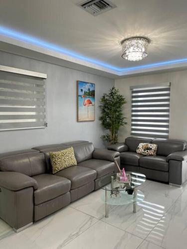 a living room with a leather couch and a table at Flamingo Paradise in Hialeah