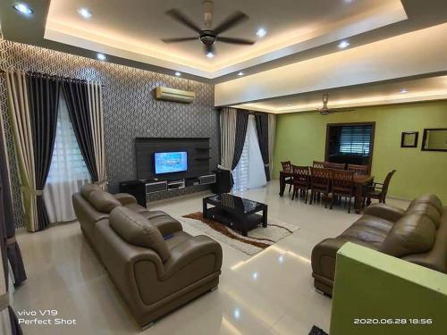 a large living room with couches and a television at Homestay Teratak Zuarie Segamat in Segamat
