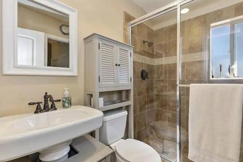 a bathroom with a sink and a toilet and a shower at Whispering Pines A-Frame, Pool Table, 2 Patios! in Lake Arrowhead