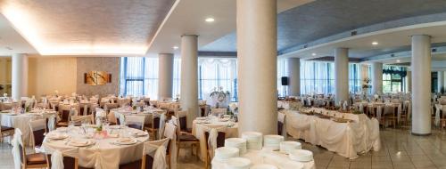 a banquet hall with white tables and chairs at Hotel Le Ginestre in Roccacasale