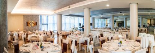a banquet hall with white tables and chairs at Hotel Le Ginestre in Roccacasale