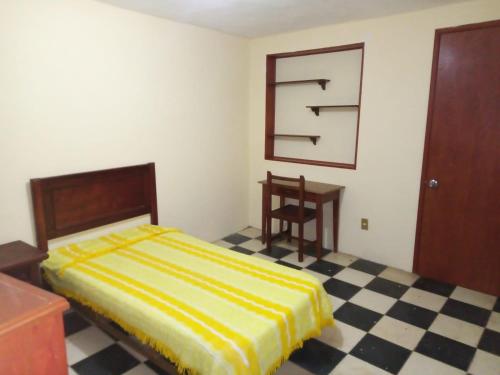a bedroom with a bed and a checkered floor at Casa Alvarado in Guanajuato