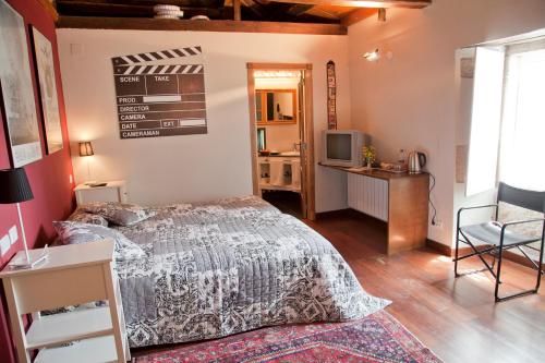 sypialnia z łóżkiem, biurkiem i telewizorem w obiekcie Pazo de Verdes w mieście Cospeito