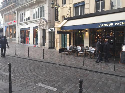 a city street with people walking in front of buildings at Hôtel Allety in Paris