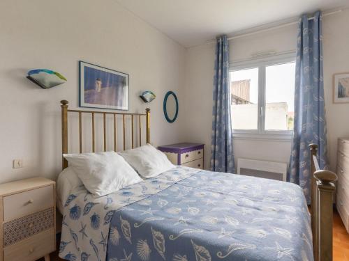une chambre avec un lit avec une couette bleue et une fenêtre dans l'établissement T3 à Mimizan Plage, 250m de l'océan, parking privé, pour 6 pers. - FR-1-50-111, à Mimizan