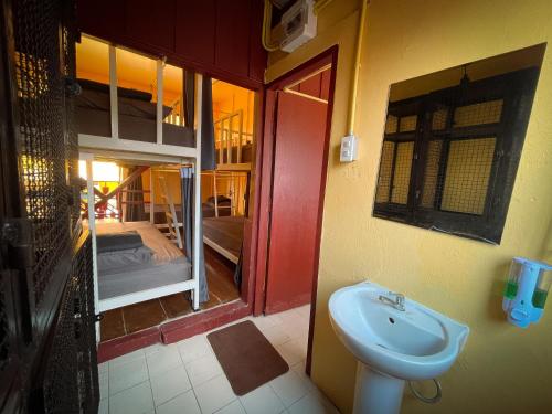 a bathroom with a sink next to a bedroom at Yellow Fellow Hostel in Chiang Mai