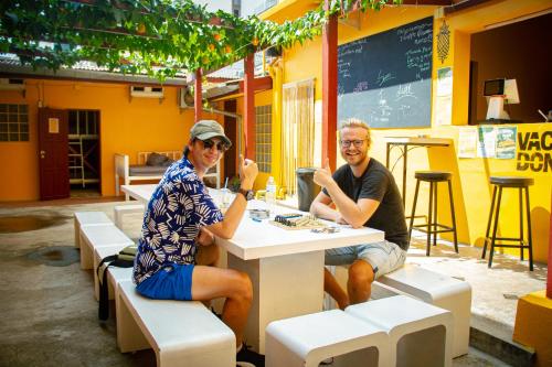 a man and woman sitting at a table in a restaurant at Yellow Fellow Hostel in Chiang Mai