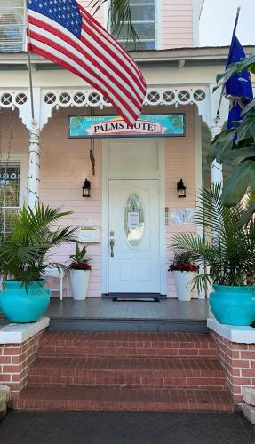 a front door of a pink house with an american flag at The Palms Hotel in Key West