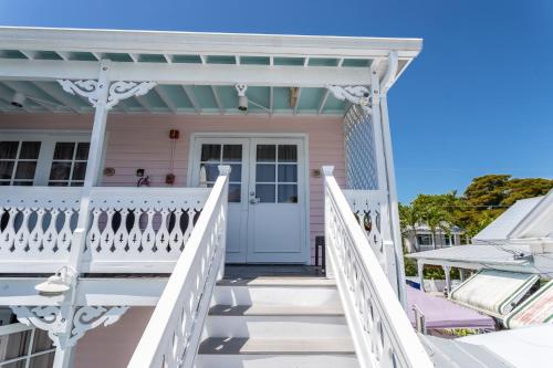a pink house with a white porch and white railings at The Palms Hotel in Key West