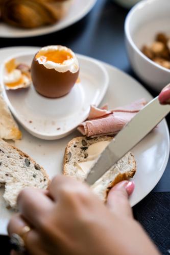 a person cutting an egg on a plate with a knife at Aura Castle in Picquigny