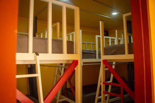 a room with bunk beds and two red chairs at Yellow Fellow Hostel in Chiang Mai