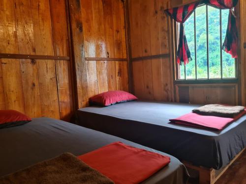 two beds in a room with a window at Ba Be Retreat in Bak Kan