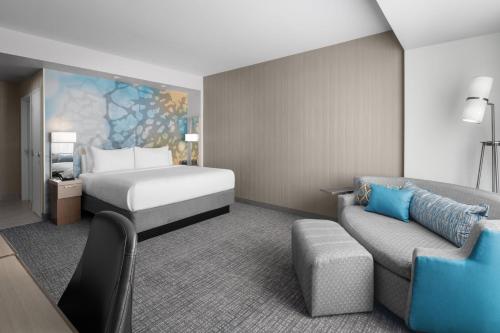 a hotel room with a bed and a couch at Courtyard by Marriott Clearwater Beach in Clearwater Beach
