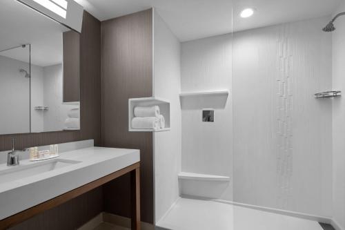 a white bathroom with a sink and a shower at Courtyard by Marriott Clearwater Beach in Clearwater Beach